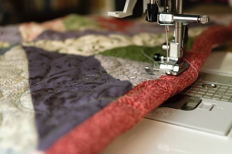 a close up of a sewing machine with a quilting project